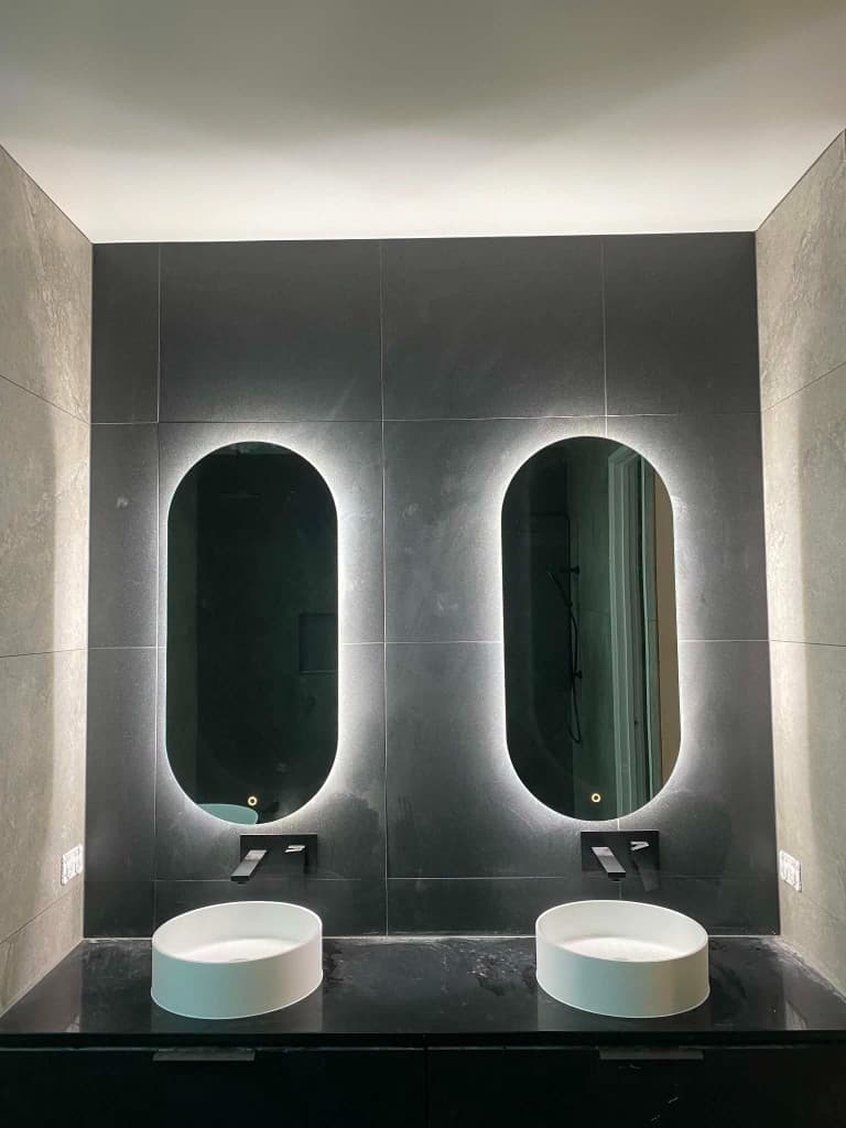 Twin vessel sinks with backlit oval mirrors