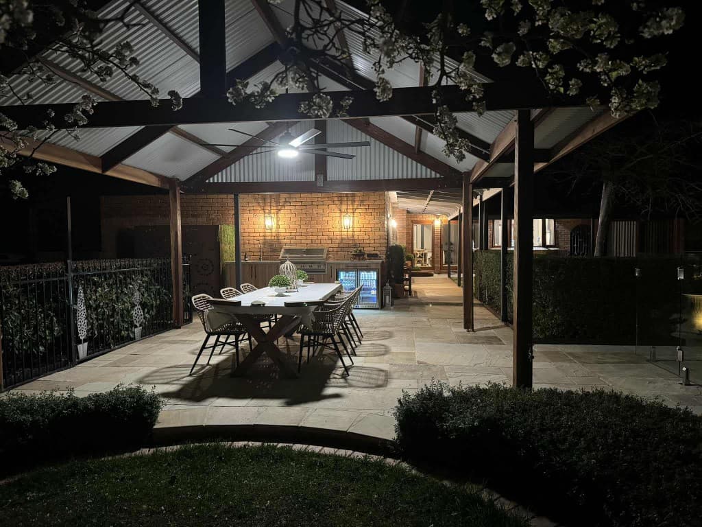 Outdoor entertaining area with pavilion lighting at night
